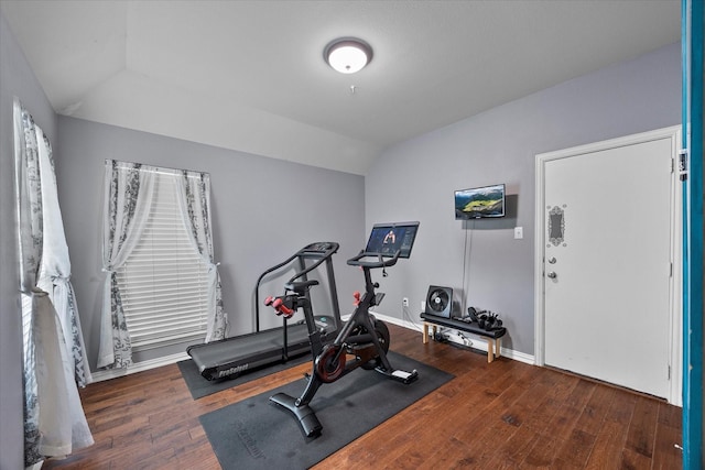 workout room featuring lofted ceiling, wood finished floors, and baseboards