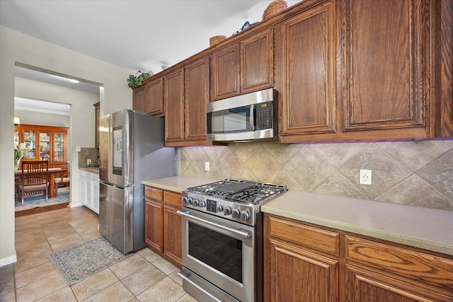 547 Reed Dr, Fate, TX 75087 - kitchen with stainless steel appliances, light tile patterned floors, tasteful backsplash, and light countertops