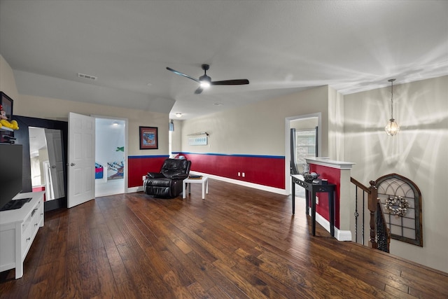 living area with visible vents, a ceiling fan, an upstairs landing, baseboards, and hardwood / wood-style flooring