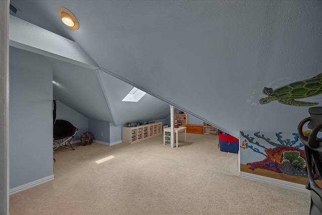 additional living space with carpet floors, vaulted ceiling with skylight, and baseboards