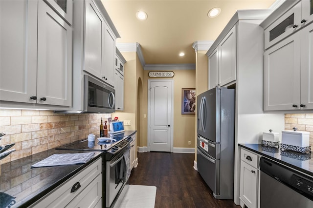 kitchen with stainless steel appliances, baseboards, dark wood finished floors, backsplash, and ornamental molding