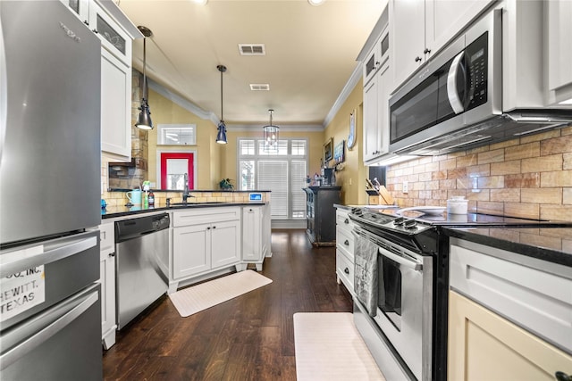 kitchen featuring crown molding, a sink, stainless steel appliances, a peninsula, and visible vents