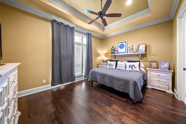 bedroom with a raised ceiling, wood finished floors, baseboards, and ornamental molding