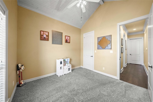 unfurnished bedroom featuring dark colored carpet, a ceiling fan, ornamental molding, baseboards, and high vaulted ceiling