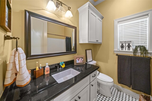 full bath featuring toilet, vanity, curtained shower, and baseboards