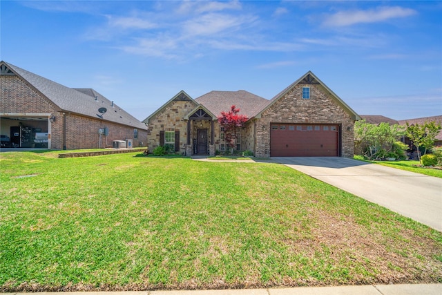 french provincial home featuring an attached garage, driveway, a front yard, and central AC unit