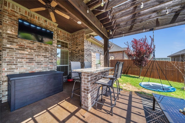 view of patio / terrace featuring fence, ceiling fan, and outdoor dry bar