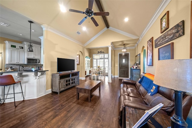 living area featuring ceiling fan, arched walkways, visible vents, and beamed ceiling