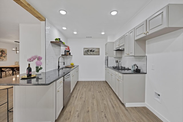 kitchen with a sink, light wood-style floors, open shelves, and a peninsula