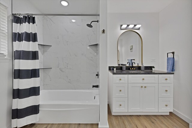 full bathroom with vanity, wood finished floors, baseboards, recessed lighting, and shower / tub combo