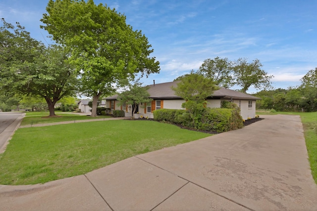 ranch-style house with concrete driveway and a front yard
