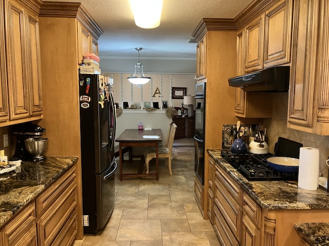 kitchen with brown cabinetry, black appliances, decorative backsplash, and under cabinet range hood