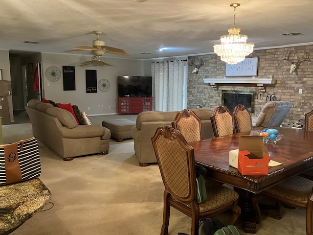 dining space featuring ceiling fan with notable chandelier, light carpet, a brick fireplace, and visible vents