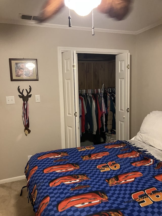 bedroom with baseboards, a closet, ceiling fan, carpet floors, and ornamental molding
