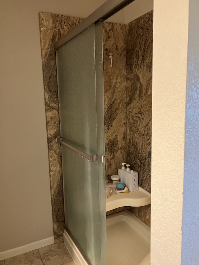 bathroom with tile patterned flooring and a shower stall
