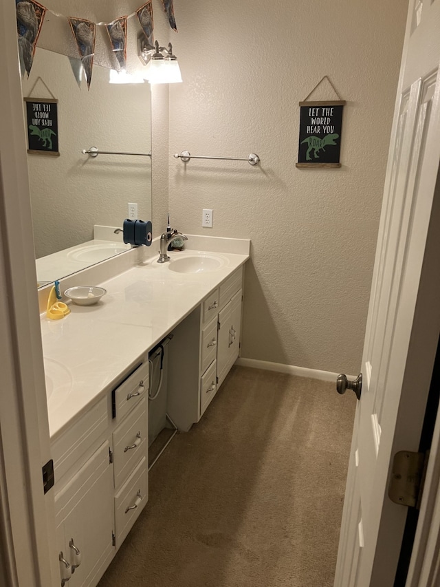 full bath with baseboards, a sink, and double vanity