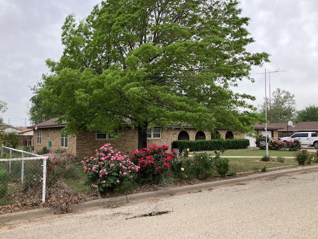 obstructed view of property featuring brick siding and fence