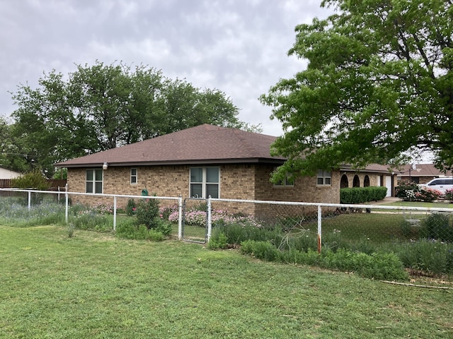 view of property exterior featuring brick siding, fence, a garage, and a lawn