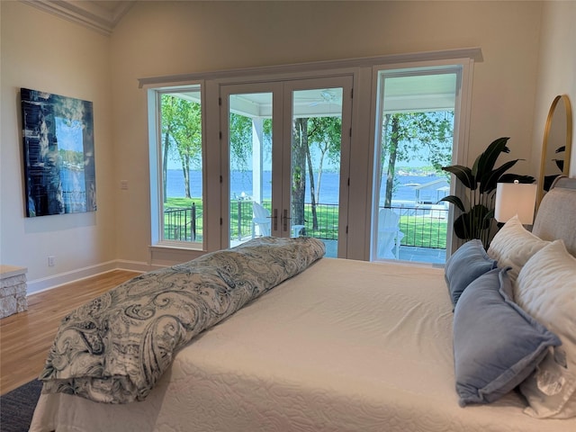 bedroom featuring crown molding, french doors, wood finished floors, and multiple windows