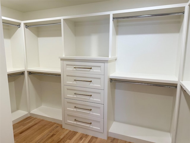 walk in closet with light wood-style floors