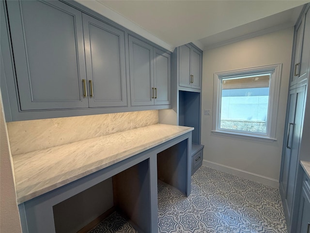 interior space with baseboards and crown molding