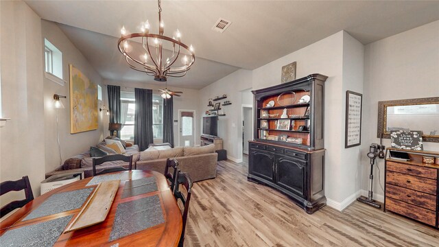 dining area featuring baseboards, a notable chandelier, visible vents, and light wood-type flooring