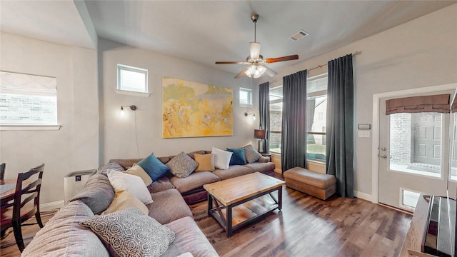 living area with baseboards, wood finished floors, visible vents, and a ceiling fan