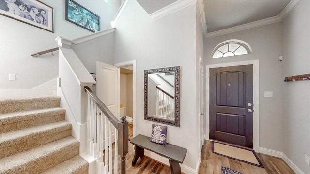 entrance foyer featuring stairway, light wood-type flooring, and ornamental molding