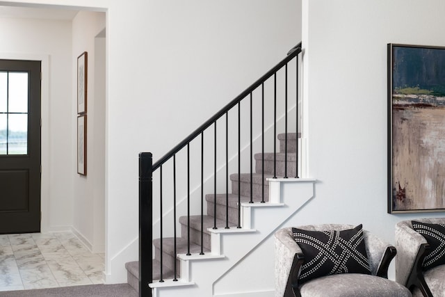 foyer with baseboards, stairs, and marble finish floor