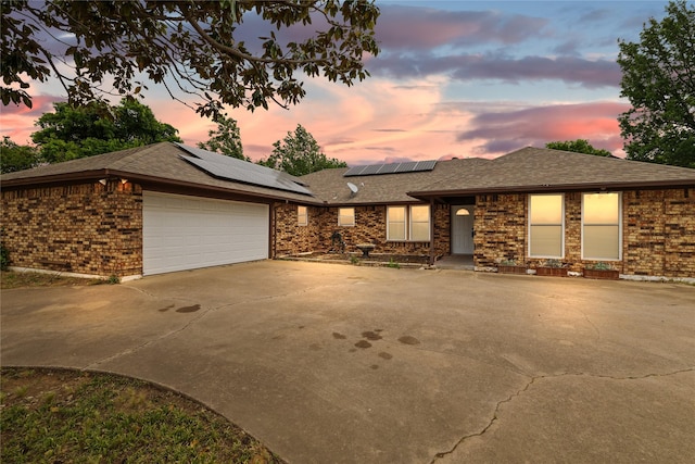 6245 Century Dr, Kennedale, TX 76060 - view of front of house with concrete driveway, roof mounted solar panels, a garage, brick siding, and roof with shingles