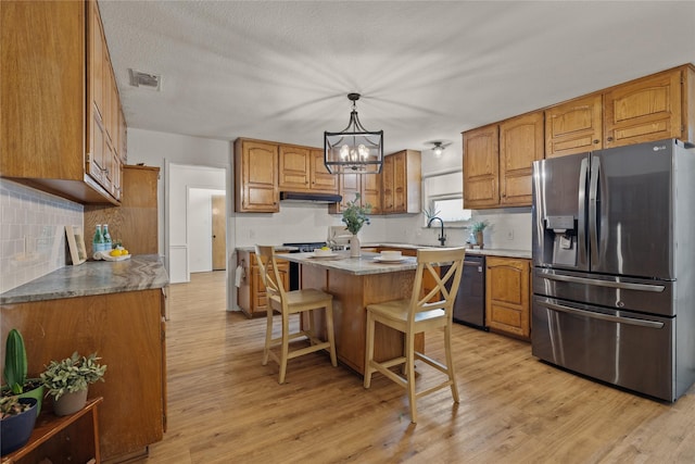 6245 Century Dr, Kennedale, TX 76060 - kitchen featuring brown cabinetry, light wood-type flooring, dishwasher, stainless steel fridge, and visible vents