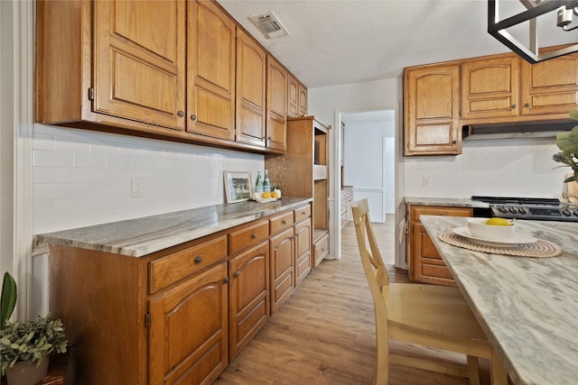 6245 Century Dr, Kennedale, TX 76060 - kitchen featuring decorative backsplash, light wood-style flooring, visible vents, and brown cabinetry