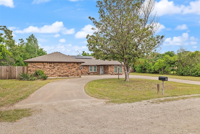 6245 Century Dr, Kennedale, TX 76060 - ranch-style house featuring fence, a front yard, curved driveway, and solar panels