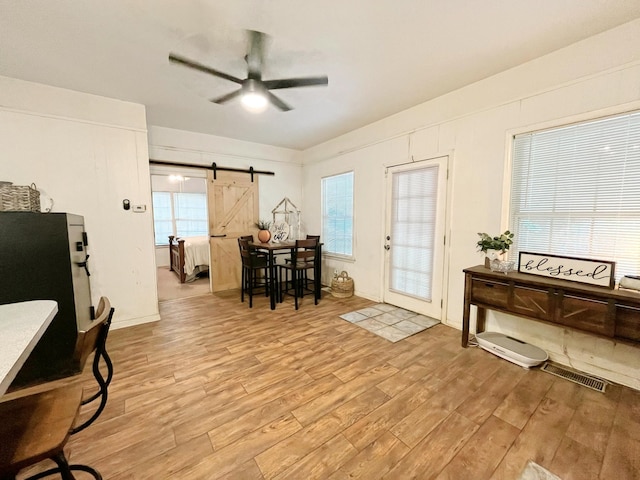 107 N Main St, Crandall, TX 75114 - entryway with a barn door, a ceiling fan, visible vents, and light wood finished floors