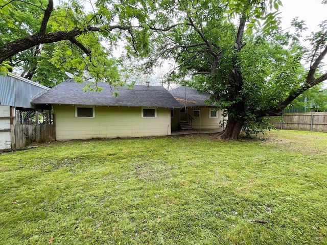 107 N Main St, Crandall, TX 75114 - rear view of property with concrete block siding, fence, a lawn, a shingled roof, and a patio
