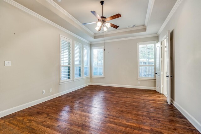 unfurnished room with dark wood-style floors, a tray ceiling, visible vents, crown molding, and ceiling fan