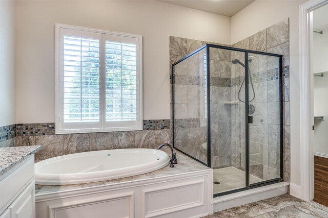 full bathroom with vanity, a garden tub, a stall shower, and plenty of natural light
