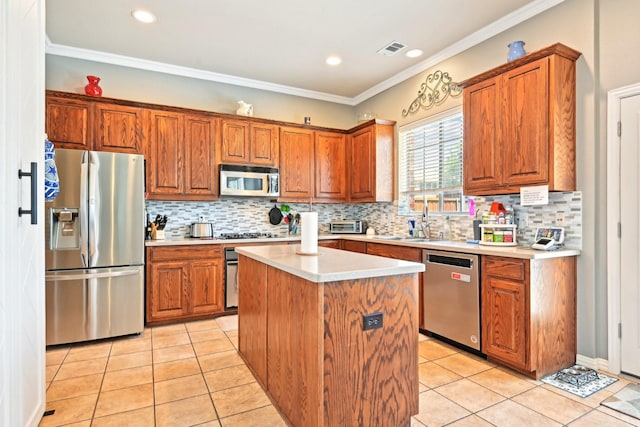 202 Beacon Hill Ln, Forney, TX 75126 - kitchen with stainless steel appliances, a sink, light tile patterned flooring, brown cabinetry, and ornamental molding