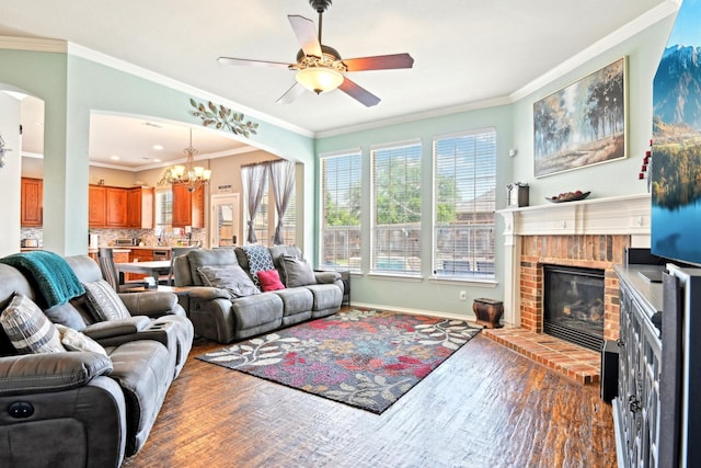 202 Beacon Hill Ln, Forney, TX 75126 - living room featuring wood finished floors, a fireplace, a chandelier, crown molding, and a ceiling fan