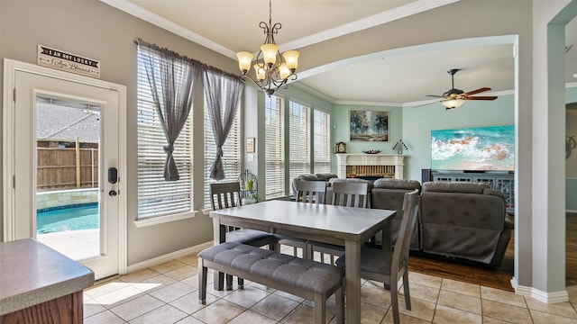 202 Beacon Hill Ln, Forney, TX 75126 - dining area with crown molding, light tile patterned floors, a fireplace, a chandelier, and a ceiling fan