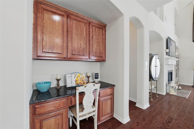 5808 Arabian Dr, Grand Prairie, TX 75052 - office space featuring arched walkways, dark wood finished floors, baseboards, and built in desk