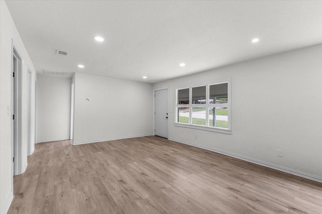unfurnished room featuring baseboards, recessed lighting, visible vents, and light wood-style flooring