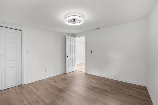 interior space with wood finished floors, visible vents, and baseboards