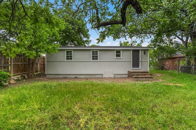 back of house with fence, entry steps, and a yard