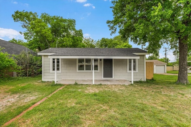 view of front facade featuring roof with shingles, a garage, and a front yard