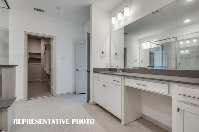 full bathroom featuring a shower stall, vanity, a spacious closet, and visible vents