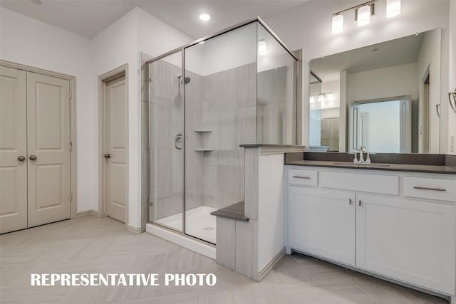 full bathroom with baseboards, vanity, and a stall shower