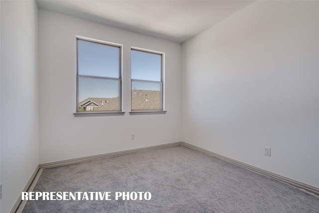 carpeted empty room with baseboards