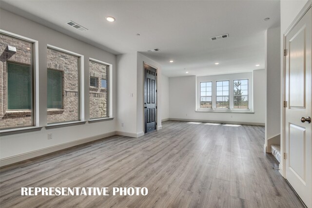 unfurnished room with recessed lighting, visible vents, baseboards, and wood finished floors