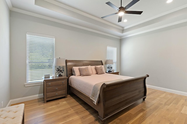 bedroom with light wood finished floors, a raised ceiling, baseboards, ornamental molding, and recessed lighting